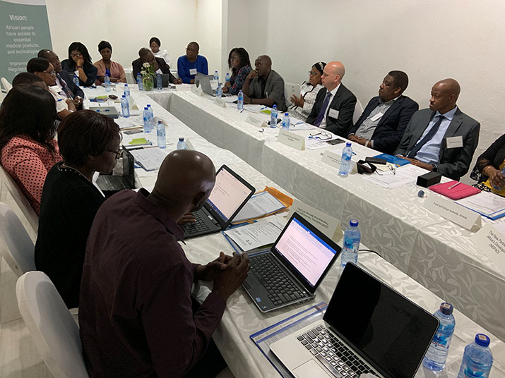 Participants sit around a table in the meeting