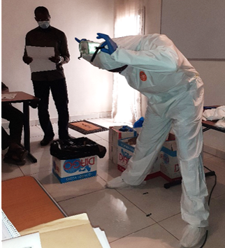 Participant demonstrating wearing and removing personal protective equipment. (Photo credit: Famory Samassa, Senior Technical Advisor, IPC/MTaPS)