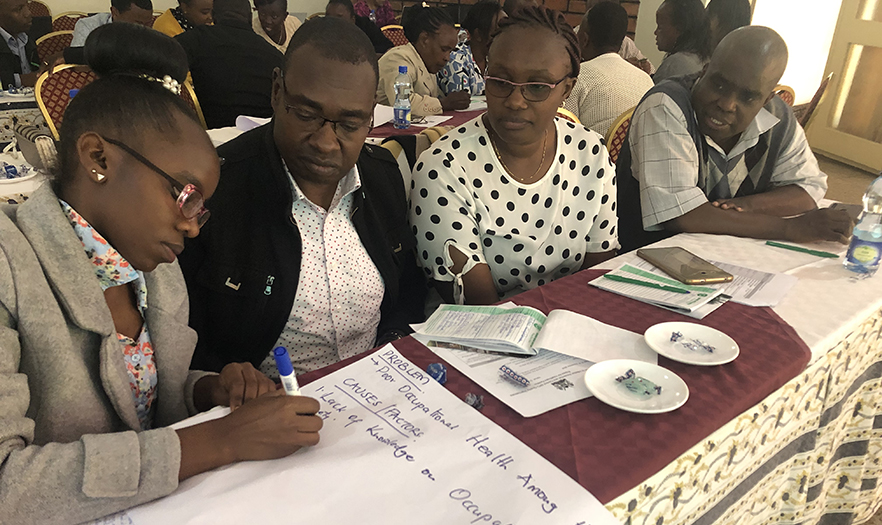 A group of participants in the training work together at a table