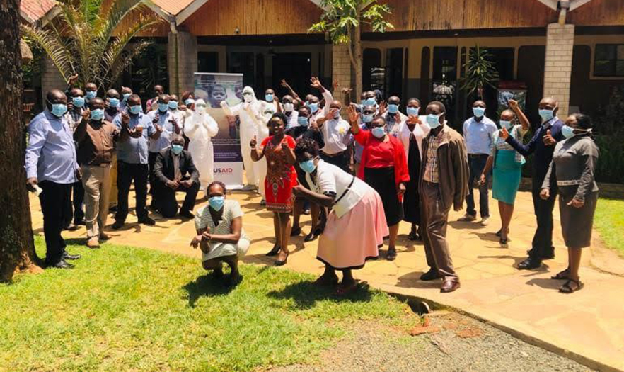 Training participants, all wearing masks, pose for a photo.