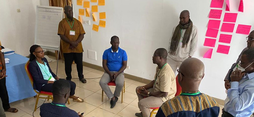 Participants sitting in a circle, discussing preventive measures and the risks and consequences of poor management of health waste