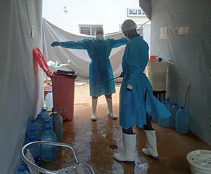Decontamination of community health workers during PPE removal. Photo credit: Mame Mbaye/MTaPS