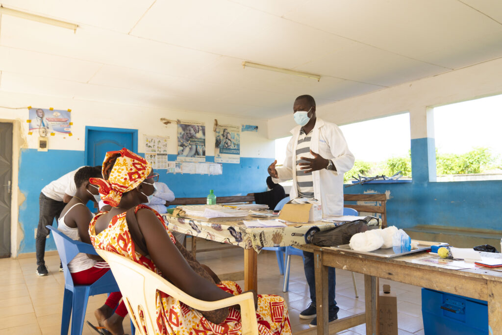 Prosper explaining the vaccination process to Béatrice and her daughter.