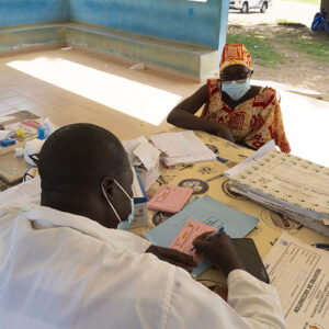 A health worker and a woman sitting around a table