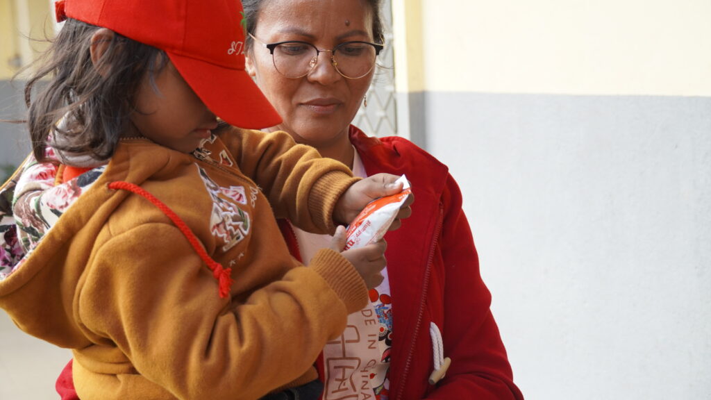 A girl holding a nutrition packet in Antsirabe, Madagascar.